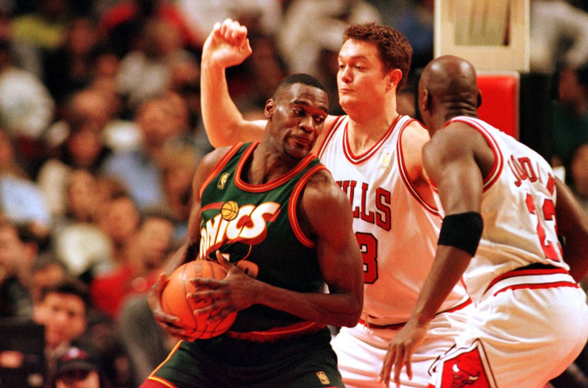Seattle-Forward Shawn Kemp versucht sich mit Ball gegen Luc Longley und Michael Jordan (re.) durchzusetzen Basketball Herren NBA, Saison 1996 97: Chicago Bulls - Seattle Supersonics Gruppe United Cent ...