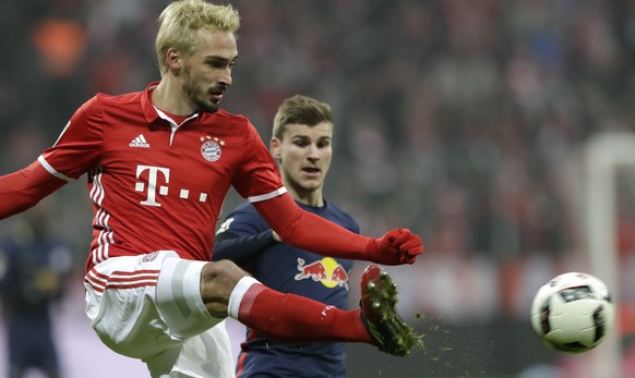 Bayern&#039;s Mats Hummels, foreground, kicks the ball in front of Leipzig&#039;s Timo Werner during the German Bundesliga soccer match between FC Bayern Munich and RB Leipzig at the Allianz Arena sta ...