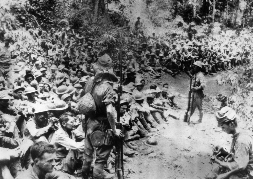 Japanische Soldaten bewachen US-Soldaten in Kriegsgefangenschaft. Das Bild entstand 1942 nach der japanischen Besetzung der Philippinen.