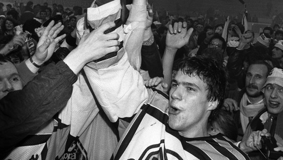 Der Lugano-Spieler Joerg Eberle praesentiert am 2. Maerz 1986 in Davos den jubelnden Fans den Meisterbecher. Diese Saison wird der Schweizermeister erstmals im Playoff-Modus ermittelt. Der HC Lugano g ...