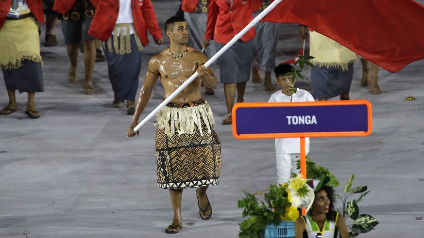 CORRECTS SPELLING OF NAME TO TAUFATOFUA INSTEAD OF AUFATOFUA - Pita Nikolas Taufatofua carries the flag of Tonga during the opening ceremony for the 2016 Summer Olympics in Rio de Janeiro, Brazil, Fri ...