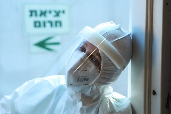 epa08705544 A medical personnel with a full protective suit rests during a break at the coronavirus COVID-19 department at the Shaare Zedek Medical Center in Jerusalem, Israel, 29 September 2020. Acco ...