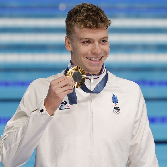 epa11504199 Gold medalist Leon Marchand of France poses after the Men 400m Freestyle final of the Swimming competitions in the Paris 2024 Olympic Games, at the Paris La Defense Arena in Paris, France, ...