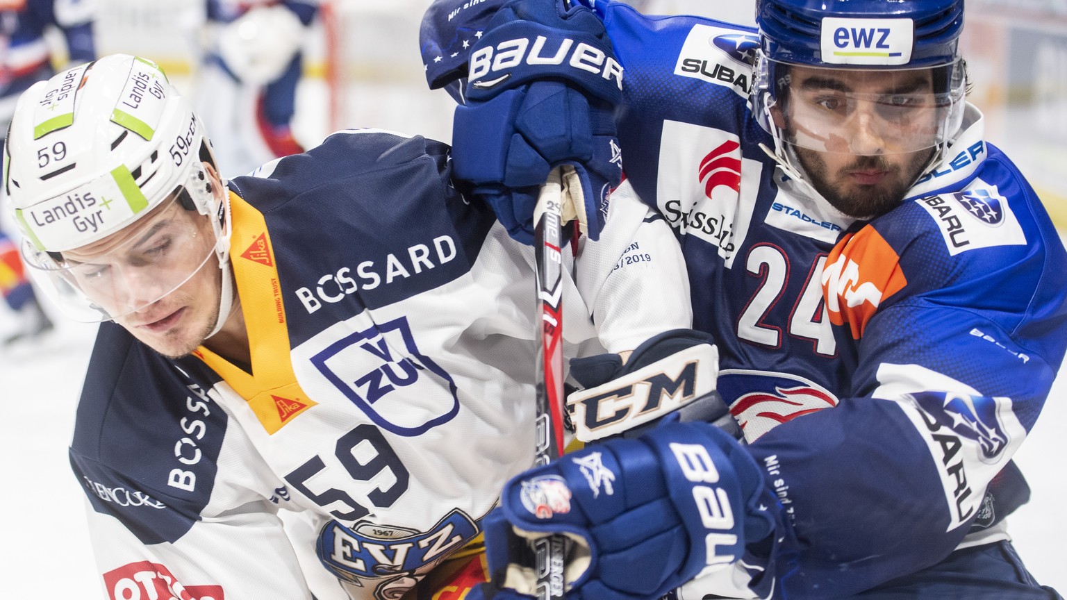 Zugs Dario Simion kaempft um den Puck gegen Zuerichs Phil Baltisberger im Eishockeyspiel der National League zwischen den ZSC Lions und dem EV Zug am Dienstag, 13. November 2018, im Zuercher Hallensta ...