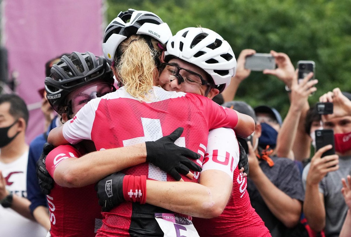 epa09369249 Swiss cyclists winner Jolanda Neff (C), second placed Sina Frei (L) and third placed Linda Indergand celebrate after the Women's Mountain Bike Cross Country race of the Tokyo 2020 Oly ...