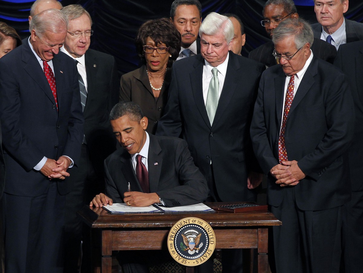FILE- In this July 21, 2010 file photo, President Barack Obama signs the Dodd-Frank Wall Street Reform and Consumer Protection financial reform bill at the Ronald Reagan Building in Washington. Standi ...