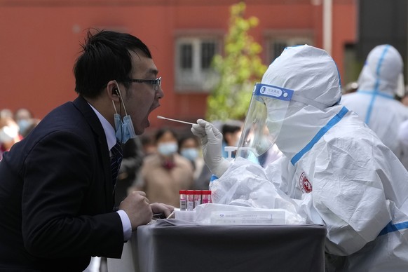 A worker gets swabbed for a COVID test outside a hotel in the Haidian district on Tuesday, April 26, 2022, in Beijing. China&#039;s capital Beijing is enforcing mass testing and closing down access to ...