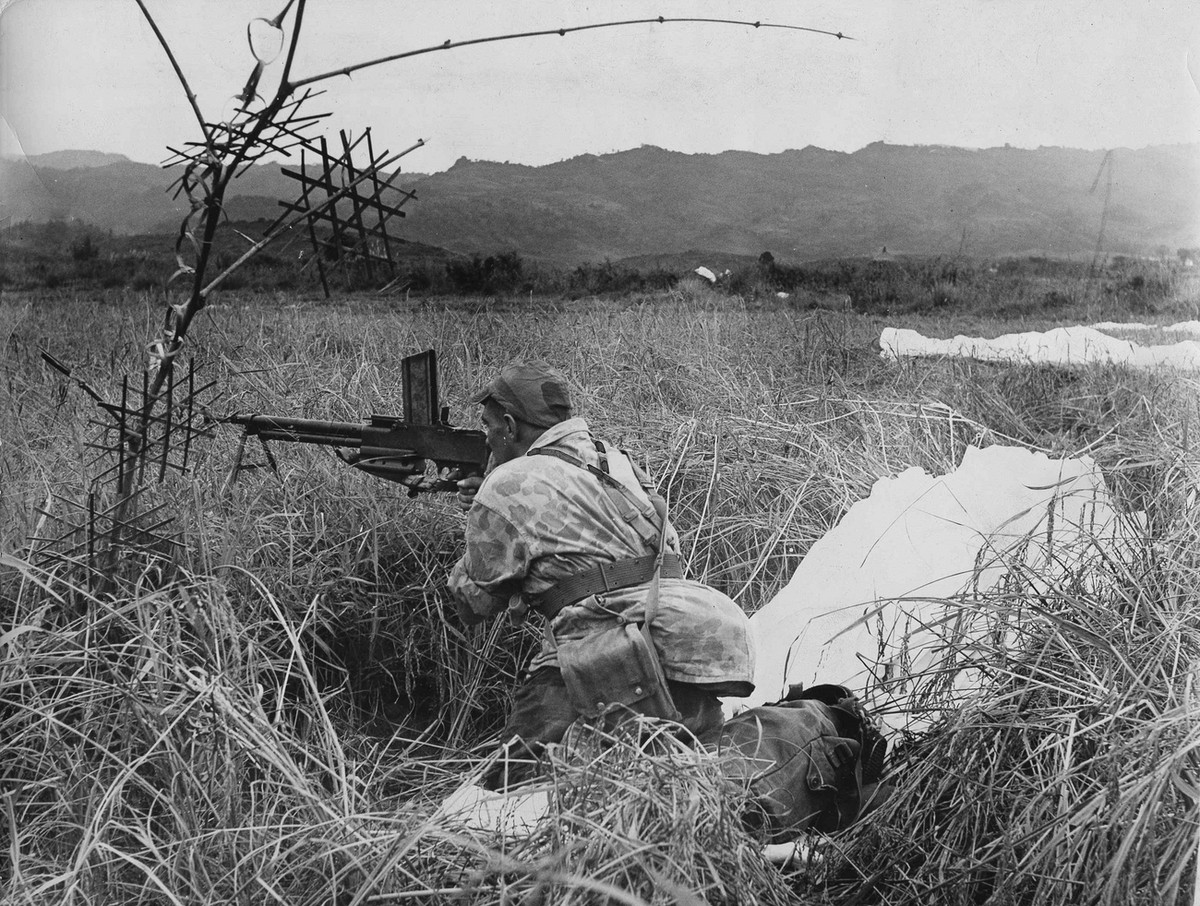 With his parachute lying beside him, a French paratrooper mans his automatic weapon during the "Operation Castor" attack on Dien Bien Phu, Indochina, Nov. 20, 1953. Several thousand French a ...