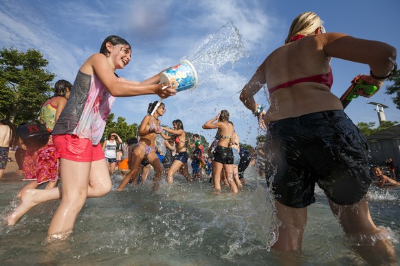 People throw water at each other during a 10-minute long water battle flash mob in Lausanne, Switzerland, Friday, July 3, 2015. The temperatures have been reaching over 35 degrees Celsius for several  ...