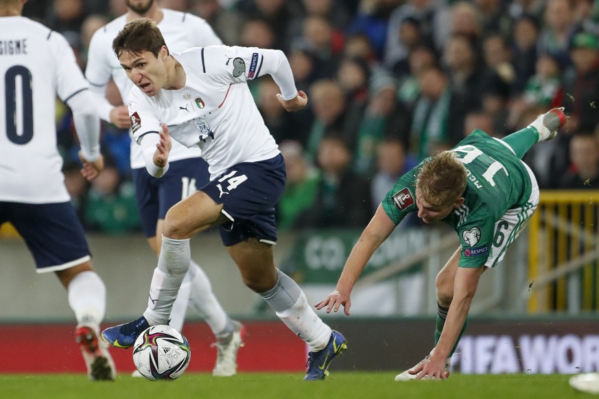 Federico Chiesa of Italy and Alistair McCann of Northern Ireland, right, compete for the ball during the World Cup 2022 group C qualifying soccer match between Northern Ireland and Italy at Windsor Pa ...