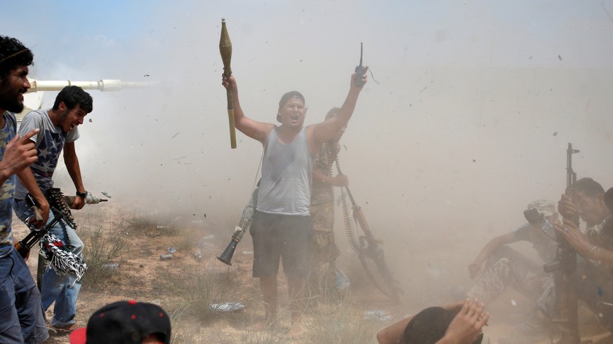 A fighter of Libyan forces allied with the U.N.-backed government gestures after other fighters fire artillery at Islamic State fighters during a battle in Sirte, Libya, July 31, 2016. REUTERS/Goran T ...