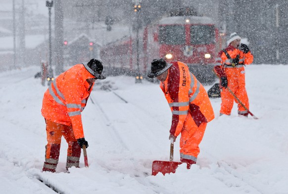 Bahnarbeiter schaufeln die Geleise der Rhaetischen Bahn, RhB, im Bahnhof Disentis vom Schnee frei, am Donnerstag, 26. Dezember 2013. Starke Schneefaelle fuehrten am Donnerstag in Kanton Graubuenden zu ...