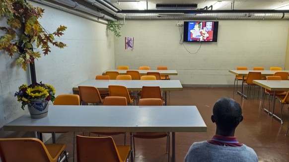 Ein Asylant schaut einen Trickfilm in der Asylunterkunft Lindenfeld, am Donnerstag, 11. September 2014, in Burgdorf. Die Zivilschutzanlage bietet rund 100 Betten, die meisten der Asylanten stammen aus ...
