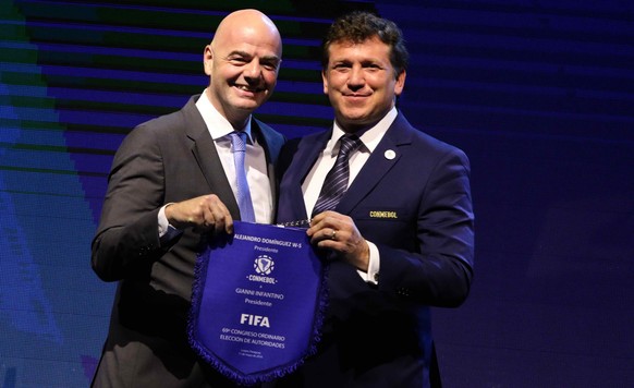 epa06728398 The president of FIFA, Gianni Infantino (L), gives a pennant to the president of the Conmebol, Alejandro Dominguez (R), after being re-elected president of the organization during the 69th ...