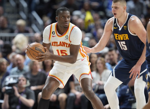 Atlanta Hawks center Clint Capela, left, looks to pass the ball as Denver Nuggets center Nikola Jokic defends in the second half of an NBA basketball game Saturday, Feb. 4, 2023, in Denver. (AP Photo/ ...