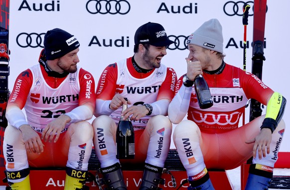 epa12589336 (from L) Second placed Luca Aerni of Switzerland, winner Loic Meillard of Switzerland and third placed Marco Odermatt of Switzerland celebrate at the end of the podium ceremony for the Men ...