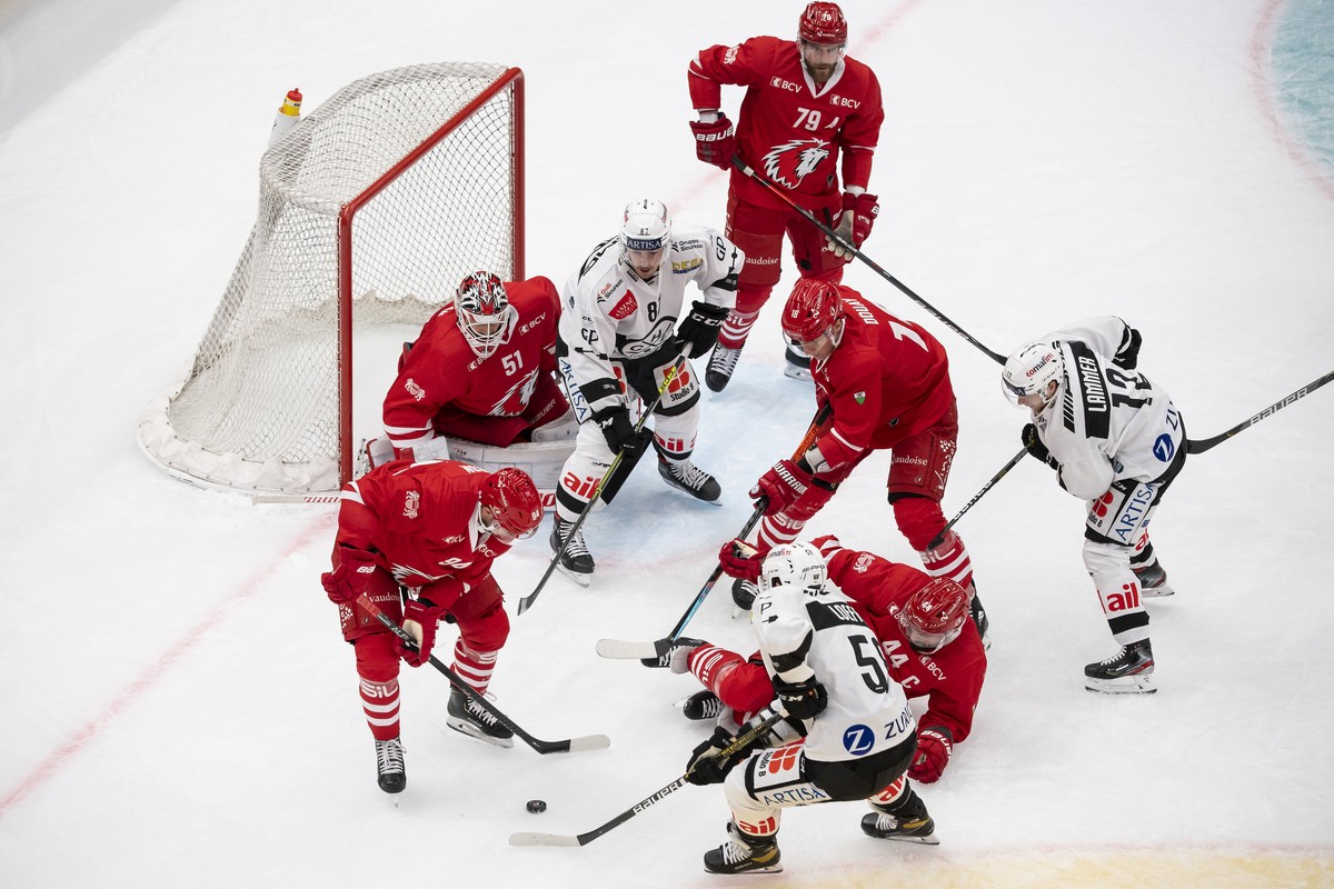 L'attaquant lausannois Tim Bozon, gauche, lutte pour le puck avec le defenseur luganais Romain Loeffel, droite, lors du match du championnat suisse de hockey sur glace de National League entre le ...