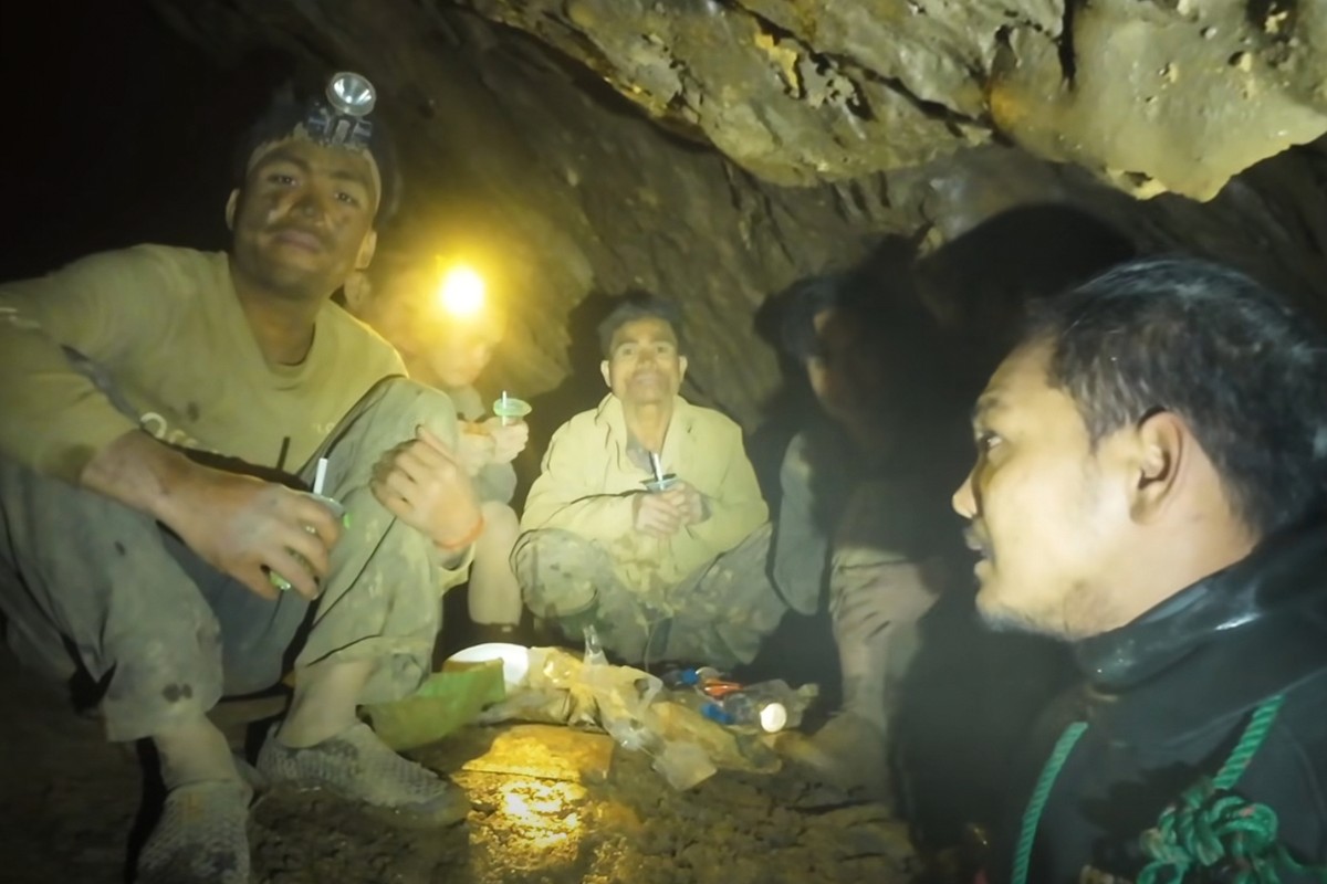 This image made from the video provided by Benz Norrased Palasing Seascout Diving shows rescuers speaking to the villagers who were trapped and found in a flooded cave in Xaisomboun province, Laos, We ...