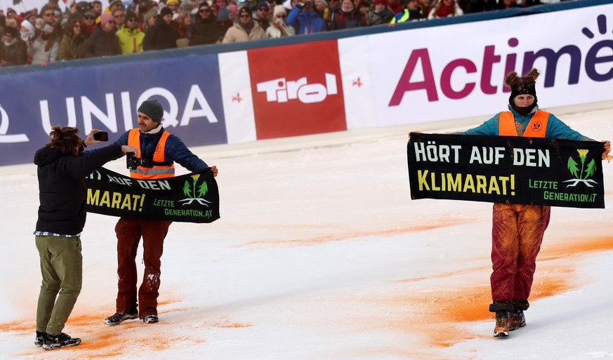 epa10982354 Climate activists hold a banner reading &#039;Listen to the Climate Council&#039; in the finish area during the second run of the Men&#039;s Slalom race of the FIS Alpine Skiing World Cup  ...