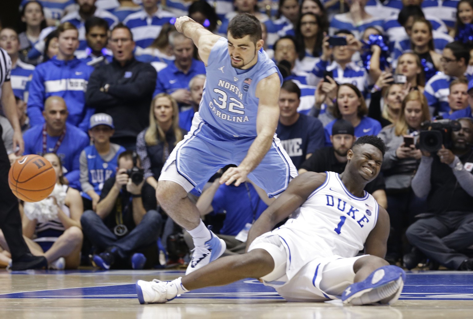 Duke&#039;s Zion Williamson (1) falls to the floor with an injury while chasing the ball with North Carolina&#039;s Luke Maye (32) during the first half of an NCAA college basketball game in Durham, N ...