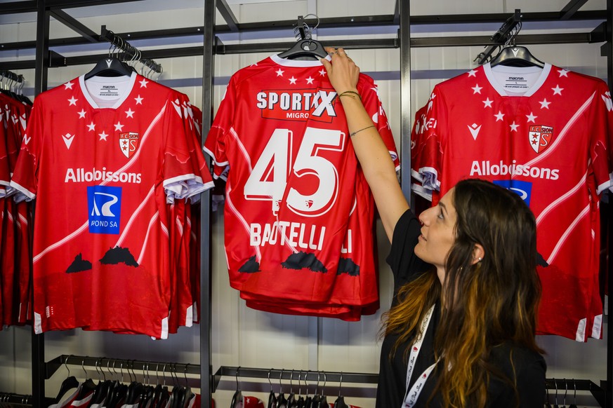 epa10157401 A saleswoman presents the jersey Sion&#039;s new forward Mario Balotelli of Italy at the club&#039;s store during the Swiss Super League soccer match between FC Sion and FC Basel, at the s ...