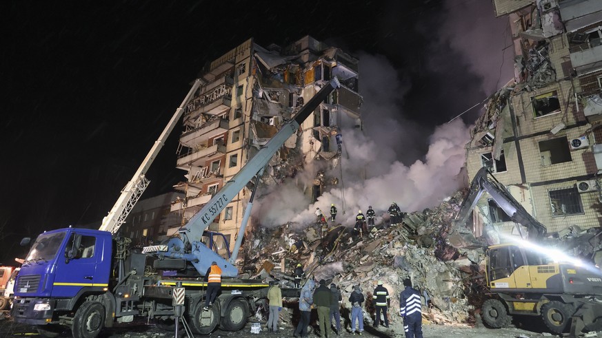 epa10406008 Rescue team work among the rubble of a damaged residential building hit by shelling in Dnipro, southeastern Ukraine, 14 January 2023, amid Russia&#039;s invasion. At least five people died ...