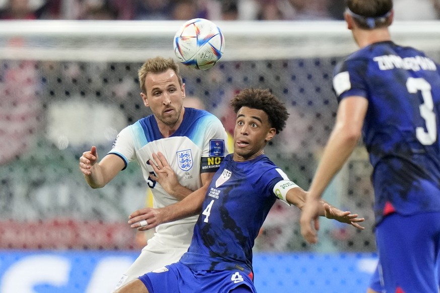 England's Harry Kane, left, vies for the ball with Tyler Adams of the United States during the World Cup group B soccer match between England and The United States, at the Al Bayt Stadium in Al Khor , ...