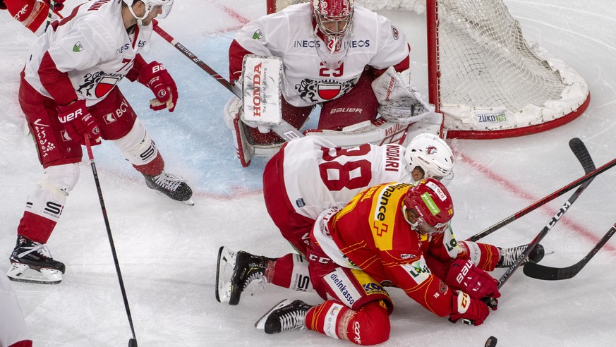 Biels Robbie Earl, rechts, kaempft um den Puck, gegen Lausannes Matteo Nodari, und Goalie Luca Boltshauser rechts, waehrend dem Meisterschaftsspiel der National Leaguel, zwischen dem EHC Biel und dem  ...