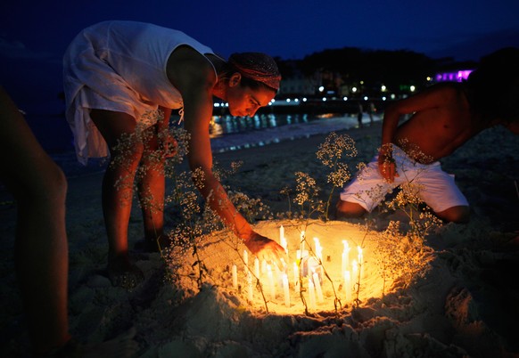 RIO DE JANEIRO, BRAZIL - DECEMBER 31: Revellers light candles on Copacabana beach during New Year&#039;s Eve celebrations on December 31, 2015 in Rio de Janeiro, Brazil. More than one million people a ...