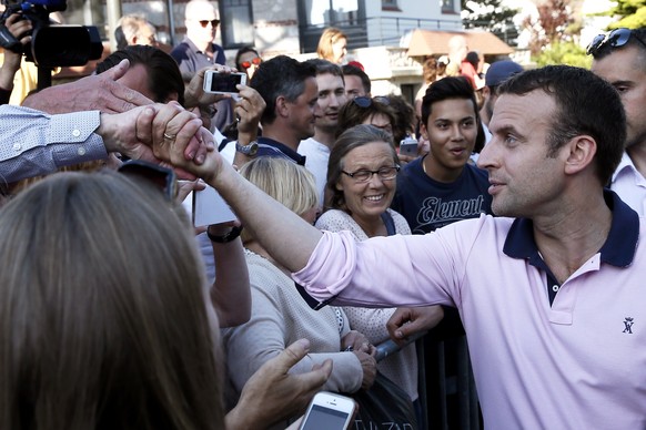 epa06034076 French President Emmanuel Macron (R) greets people gathered around his house in Le Touquet, France, 17 June 2017. The presidential couple arrived on Friday 16 June and spend the weekend he ...