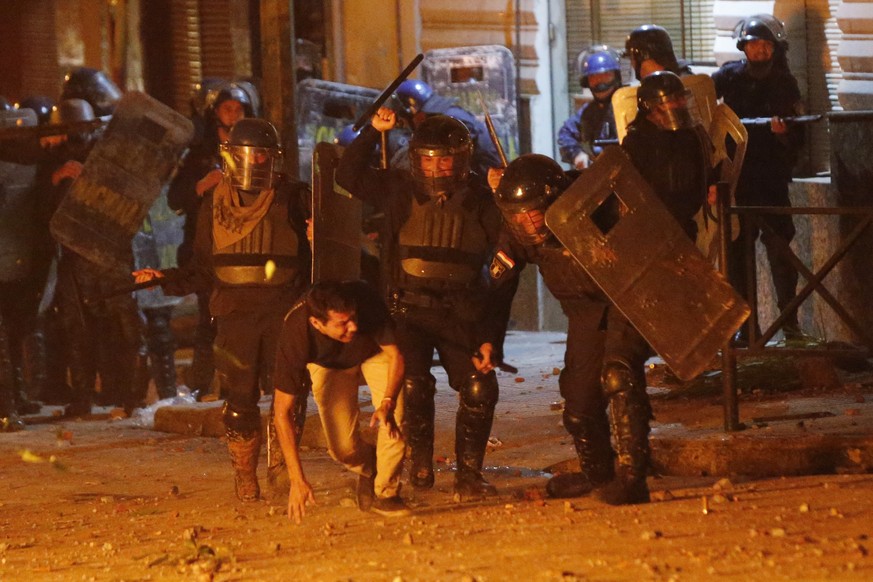 Riot police pursue a protester during a protest against the government of President Mario Abdo Benitez in response to the shortage of medications for COVID-19 patients in hospitals and the low availab ...