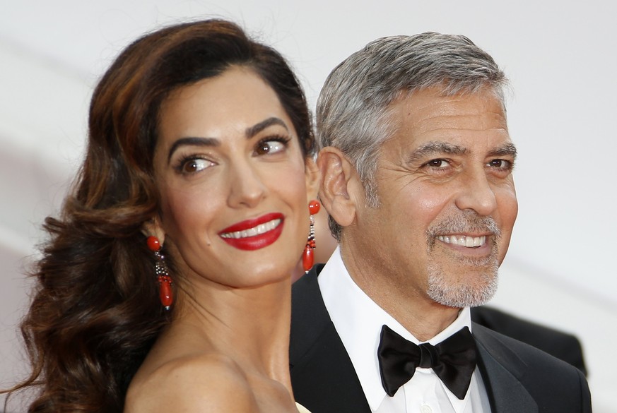 epa05782114 (FILE) A file photograph showing US actor George Clooney (R) and wife British human rights barrister Amal Clooney (L) arriving for the screening of &#039;Money Monster&#039; during the 69t ...