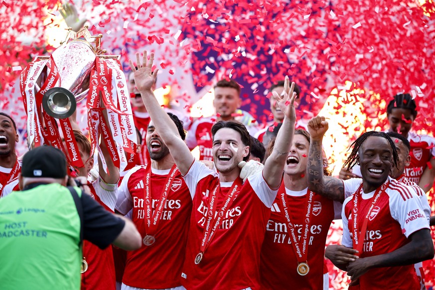 epa12991237 Arsenal player Declan Rice (C) and teammates celebrate receiving the Premier League trophy at the end of the English Premier League match Crystal Palace against Arsenal FC, in London, Brit ...