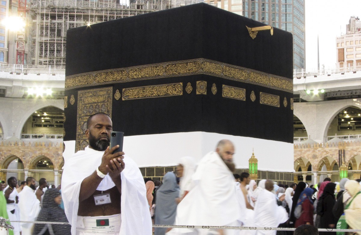 A Bangladeshi pilgrim poses for a selfie in front of the Kaaba, the cubic building at the Grand Mosque, in the Saudi Arabia's holy city of Mecca, Tuesday, July 5, 2022. Saudi Arabia is expected t ...