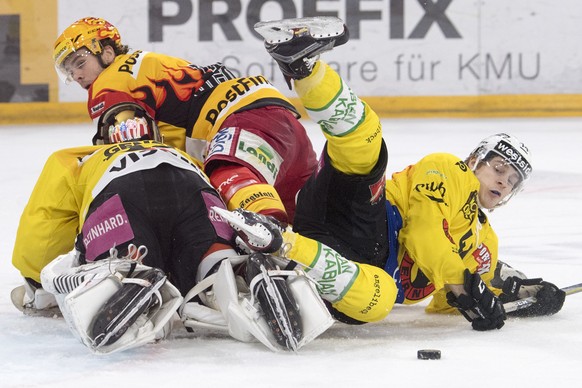 Biels Topscorer Marc-Antoine Pouliot, Mitte, kaempft um den Puck gegen Berns Leonardo Genoni, links, und Andre Hirt, rechts, waehrend dem Eishockeyspiel der National League zwischen dem EHC Biel und d ...