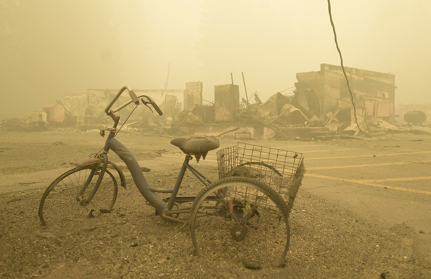 A trike that was in a small park along Detroit Avenue still stands near the Lake Detroit Market, Friday, Sept. 11, 2020, in Detroit, Ore. Smoke that poses a health hazard to millions is blanketing the ...