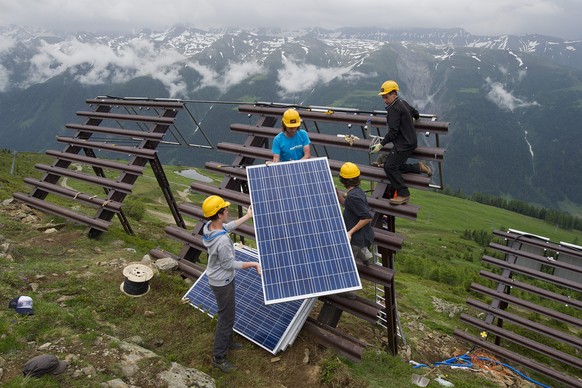 ZUR ATOMAUSSTIEGSINITIATIVE UND ZUR ENERGIESTRATEGIE 2050 STELLEN WIR IHNEN FOLGENDES BILDMATERIAL ZUR VERFUEGUNG - Des jeunes posent des panneaux solaires ou panneaux photovoltaiques sur des paravala ...