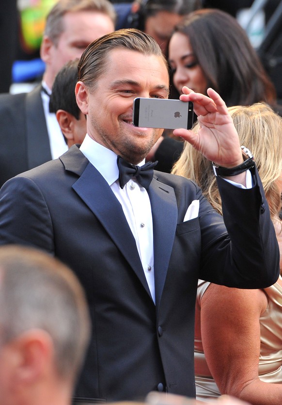 Leonardo DiCaprio uses his cell phone as he arrives at the Oscars on Sunday, March 2, 2014, at the Dolby Theatre in Los Angeles. (Photo by Vince Bucci/Invision/AP)