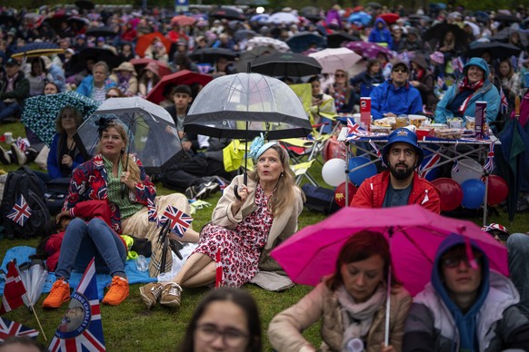 Royal fans watch the Britain&#039;s King Charles III coronation ceremony on a screen in Hyde park, in London, Saturday, May 6, 2023. (AP Photo/Emilio Morenatti)
