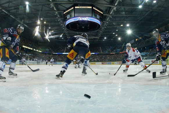 Zugs Fabian Schnyder, Dominik Schlumpf, Zuerichs Pius Suter und Zugs Raphael Diaz, von links, waehrend dem Eishockey-Qualifikationsspiel der National League A zwischen dem EV Zug und den ZSC Lions, am ...