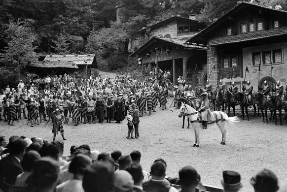 Die Zuschauer verfolgen von der Freilicht-Tribuene eine Szene, in der Wilhelm Tell und sein Sohn Walter vor einer grossen Heerschar der feindlichen Obrigkeit vorgefuehrt werden, aufgenommen 1941/42 an ...
