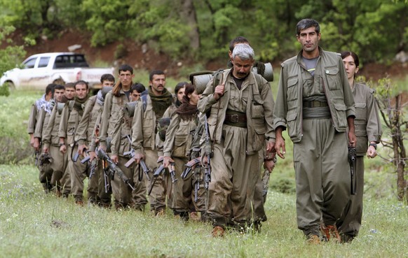 FILE - A group of armed Kurdish fighters from the Kurdistan Workers Party (PKK) enter northern Iraq in the Heror area, northeast of Dahuk, 260 miles (430 kilometers) northwest of Baghdad, Iraq, May 14 ...