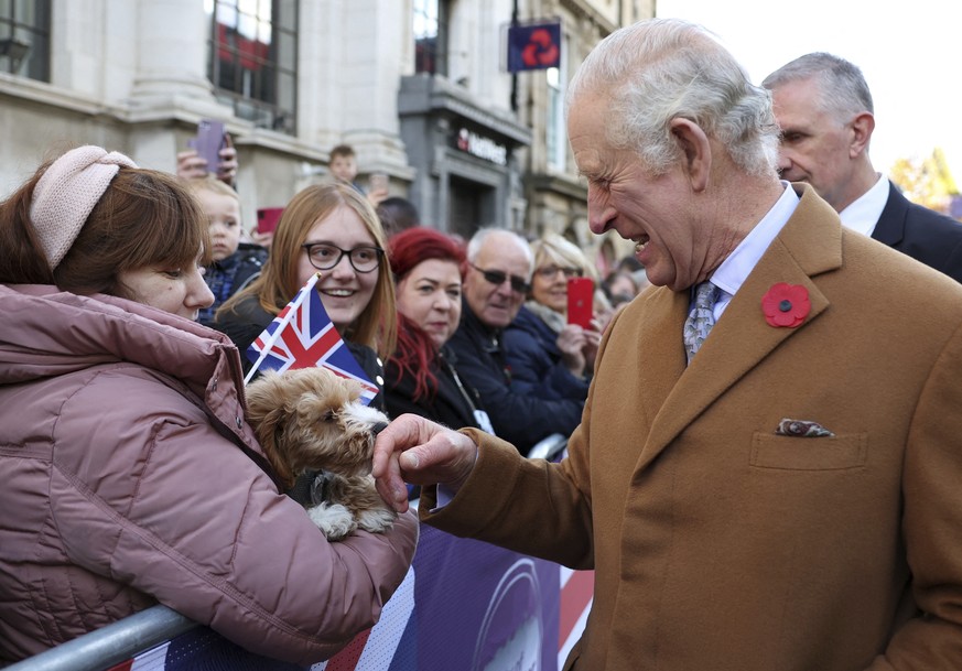 Britain&#039;s King Charles III greets a dog as he visits the Mansion House in Doncaster, England, Wednesday, Nov. 9, 2022. (Molly Darlington/Pool Photo via AP)