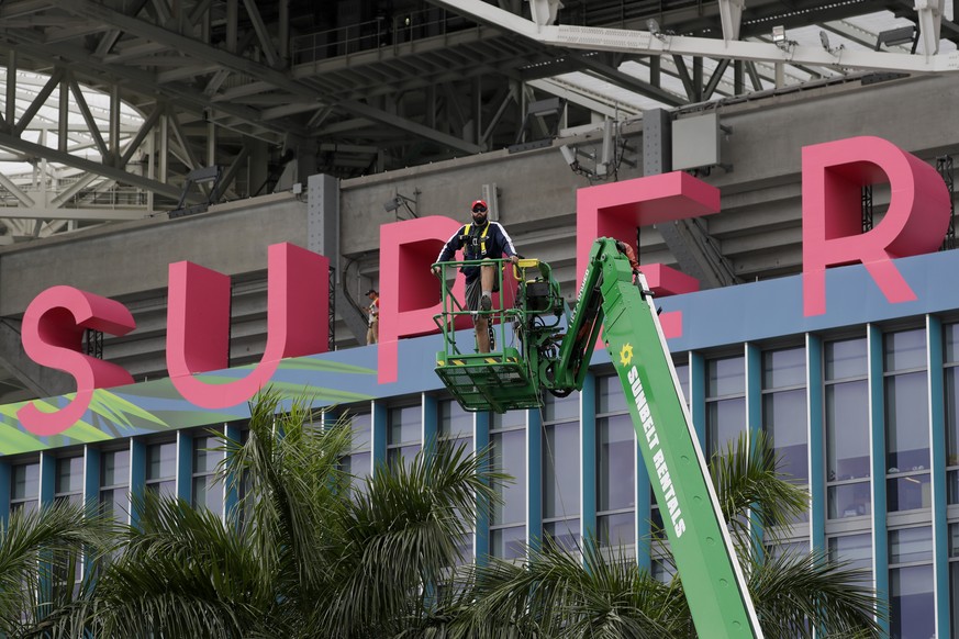 A worker strings wire outside of the Hard Rock Stadium Monday, Jan. 27, 2020, in Miami Gardens, Fla. in preparation for the NFL Super Bowl 54 football game. (AP Photo/Chris Carlson)