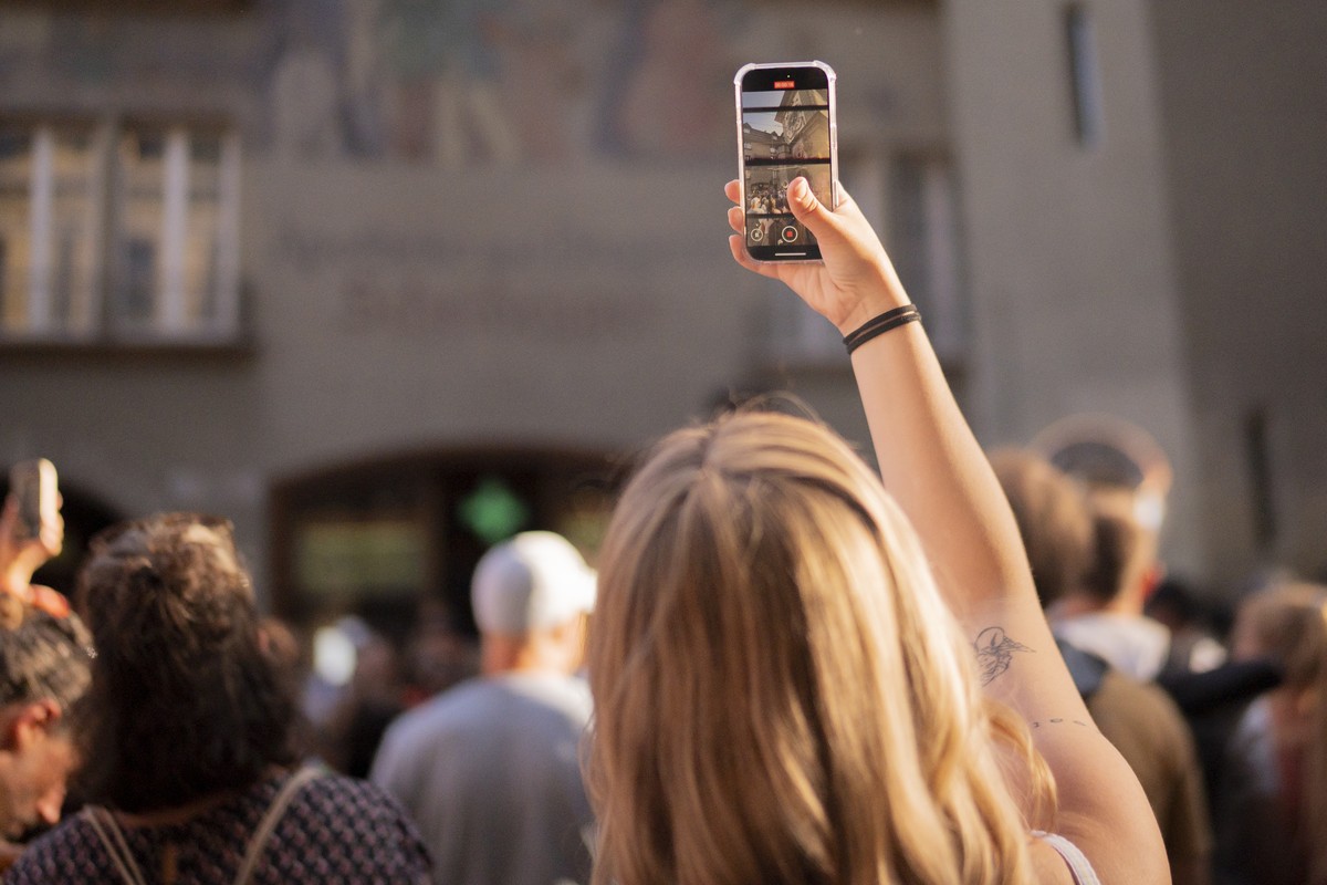 Eine Frau filmt mit ihrem Smartphone, bei der Eroeffnung des 22. Buskers Festival, am Donnerstag, 7. August 2025, in Bern. 40 Acts spielen bis und mit Samstag in der unteren Altstadt von Bern. (KEYSTO ...