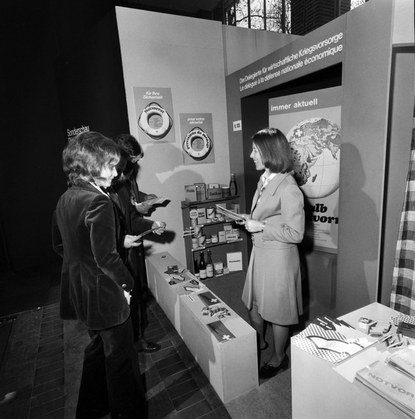 An der Schweizer Mustermesse in Basel wird der Besucher zur Anlegung von Notvorraeten aufgemuntert, aufgenommen im Jahr 1973. (KEYSTONE/PHOTOPRESS-ARCHIV/Str)