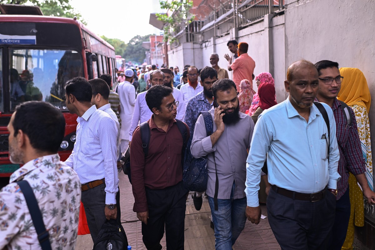 Employees at a government office leave after their working hours were reduced under energy-saving measures as Bangladesh tries to handle its energy crisis related to the Iran war, Sunday, April 5, 202 ...