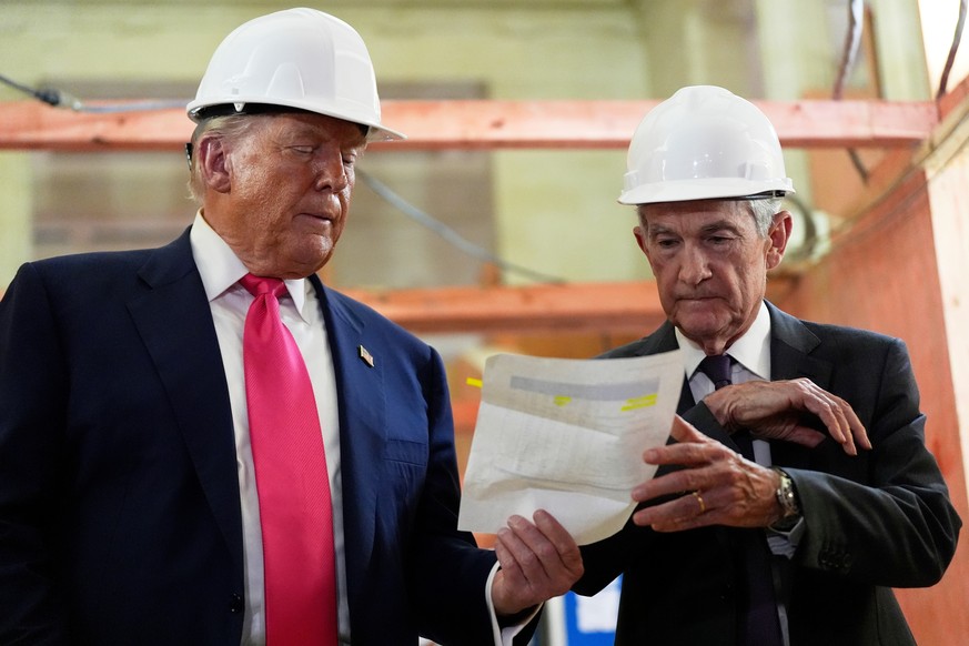 FILE - Federal Reserve Chairman Jerome Powell, right, and President Donald Trump look over a document of cost figures during a visit to the Federal Reserve, Thursday, July 24, 2025, in Washington. (AP ...