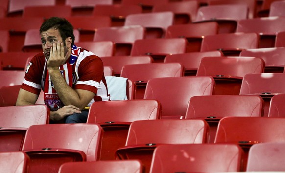 epa04223514 An Atletico Madrid supporter looks dejected after the UEFA Champions League final between Real Madrid and Atletico Madrid at Luz stadium in Lisbon, Portugal, 24 May 2014. Real Madrid become European champions for the 10th time by beating city rivals Atletico Madrid 4-1 after extra time.  EPA/MARIO CRUZ