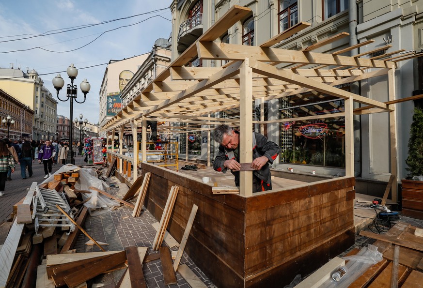 epa09142103 Workers assemble the street veranda of the restaurant on the Arbat street in Moscow, Russia, 17 April 2021. According to Russian Deputy Prime Minister Tatyana Golikova, over eight million  ...